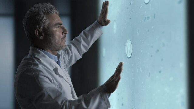 medical microbiology,scientist biologist using augmented reality screen analyzes microscope image of cells mutations divisions,biomedical science technology concept