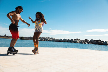Cheerful couple roller skating outside. Fun sexy boyfriend and girlfriend enjoy in sunny day.