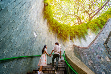 Young couple traveler with giant tree at Fort Canning Tree Tunnel in Singapore - obrazy, fototapety, plakaty