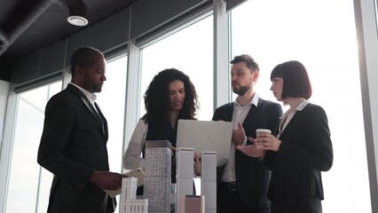 Beautiful confident curly business lady showing her financial and sales report on laptop pc for her focused high-skilled multiracial business colleagues working on city district urban planning project - Powered by Adobe