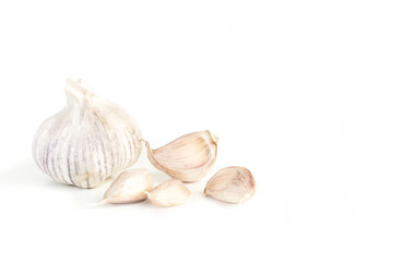Cabeza y dientes de ajos sobre un fondo blanco liso y aislado. Vista de frente y de cerca. Copy space