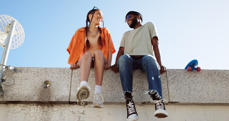 Cool, fashion and joke with young couple hang out on city building together bonding. Interracial...