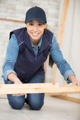 happy woman as joiner grinding wood