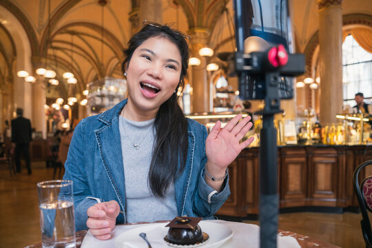 Asia travel vlogger introduce great menu famous restaurant while lives streaming for social reel video social media platform,Social media influencer online video of food at cafe, smartphone