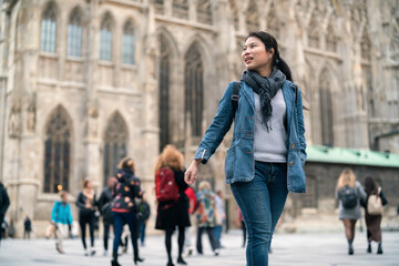 Obraz premium carefree Asian woman enjoy sight seeing travel in front of famous church in Vienna tour in downtown. Young woman exploring famous old architecture Stephansdom cathedral church in downtown