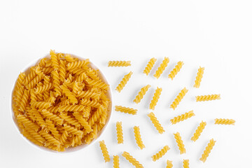 Pasta products in the form of a spiral on a plate, texture, on a white background