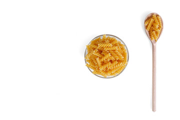 Pasta in the form of a spiral on a plate, spoon, texture, on a white background