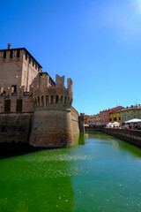 Fontanellato, Parma: the building of the castle La Rocca Sanvitale across the lake on a market day