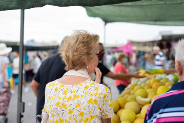 An elderly woman shopping at a ceramic flea market
