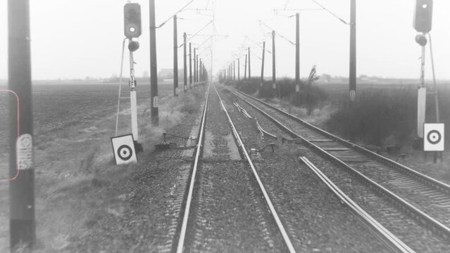 Black and White Archive footage of rails seen from the interior of a moving train