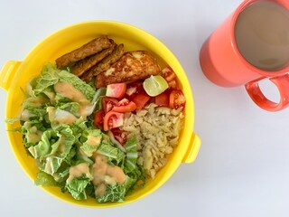 bowl of vegetable salad and hot coffee.