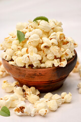 closeup the bunch white yellow popcorn with green mint leaves isolated on white background.