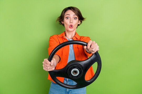 Photo of excited funny woman wear denim jacket riding car big eyes isolated green color background