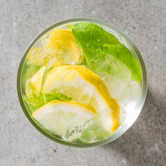 Refreshing lemonade with mint leaves and ice on gray stone table - obrazy, fototapety, plakaty