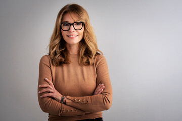 Studio portrait of an attractive middle age woman against grey background