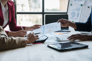 A group of Asian businessmen meet, plan and discuss data analysis, charts, graphs, financial calculations, income, taxes and business performance. marketing accounting concept.