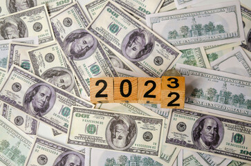 2023 wooden text block on a dollar banknote, saving and managing money, transport, transportation insurance business technology, economic crisis risk and problem concept. selective focus