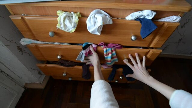 Mess of clothes in the closet. Person inaccurately stuffs clothes and linen into the closet