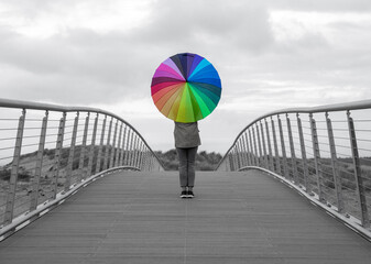 Girl on a bridge with rainbow umbrella © Sarah