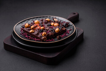 Handmade chocolate with berries, nuts and spices on a dark background