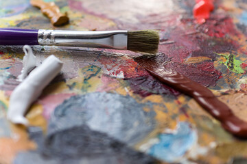 Fototapeta premium Home hobby.Drawing at home.Art school.Free time.Palette with paints.Drawing with a brush.Oil paints.Brush with paints.Palette of colors.Color mixing.Favorite hobby. Artist.Learning to draw.Colors.