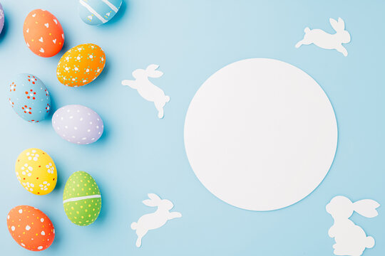Overhead easter eggs with rabbit paper cut and circle white paper isolated on blue background, Funny decoration paper round blank, Happy Easter Day, Creative banner web design holiday background