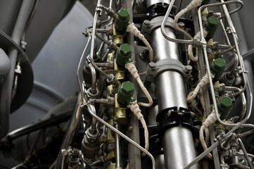 Obraz premium A close-up of a rocket engine with multiple pipelines supplying fuel and coolant to the combustion chamber. Jet engine with many titanium and stainless steel parts.