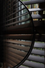 Circular Mirror Reflecting Brown Wooden Blinds 