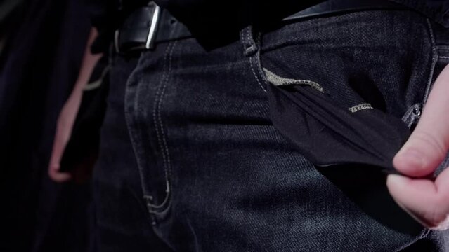 Man turns out empty pockets of jeans. The man has no money
