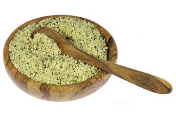 hemp seeds in an olive wood bowl with spoon isolated on white background