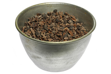 cocoa nibs in an aluminum bowl isolated on white background