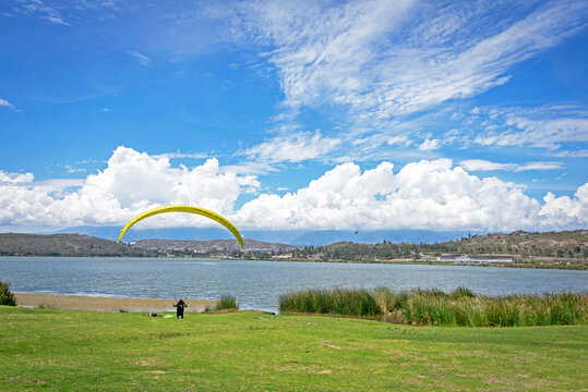 Beautiful view of the Yahuarcocha lake with a paraglider after his flight. Yahuarcocha, Imbabura province, Ecuador.