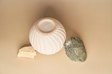 Round porcelain podium for product presentation, complemented by natural stones. An empty porcelain podium for the presentation of goods. With space to copy. High quality photo