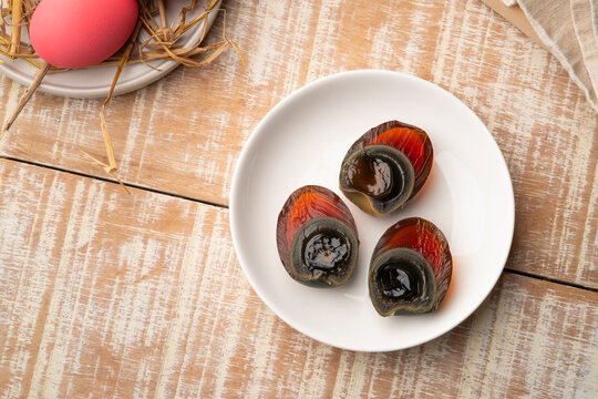 Half sliced Century egg in white plate, Pink color preserved eggs.