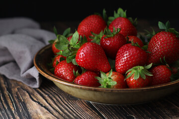A bowl with ripe bright strawberry in rustic style	