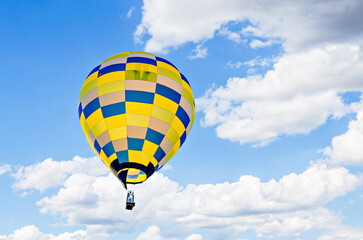 Naklejka premium Colorful hot air balloon flying over blue sky with white clouds 