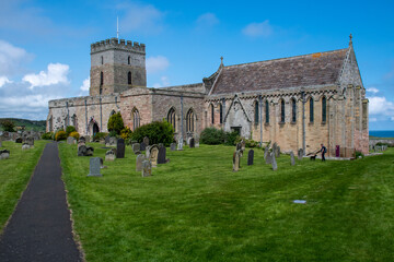Fototapeta premium The exterior of St Aidan's Church and churchyard in Bamburgh, Northumberland, UK