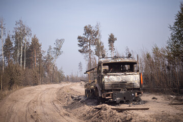 Burnt truck near the road in forest