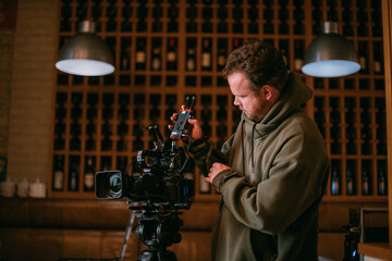 Director of photography with a camera in his hands on the set. Professional videographer at work on filming a movie
