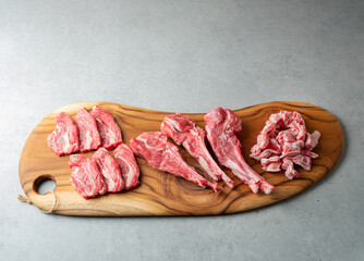 Raw lamb meat in various parts on a wooden plate