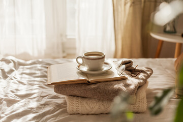 Hot mug of cappuccino on wooden tray on the bed, breakfast. Cozy house. Beige natural colors....