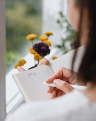view from back, woman writes notes in notebook or diary. mental health care, psychotherapy and work...