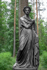 Fototapeta premium Statue of the Greek goddess Flora in the spring park. Determination, strength, power. Matriarchy. Women's rights