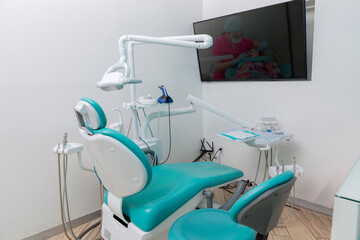 Dental office with work equipment and a screen on the wall
