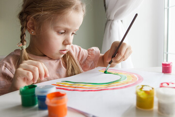 Little child draws with watercolor, concept of education in the kindergarten