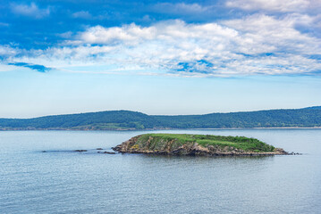 Fototapeta na wymiar Island in the sea in cloudy weather.