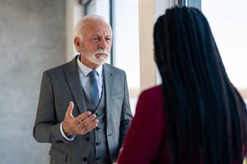 Angry senior executive manager in suit blaming and arguing with female coworker after...