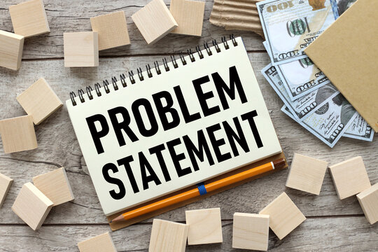 wooden cubes are scattered near the notepad with text. problem statement