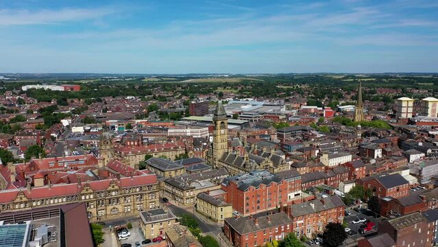 Aerial drone footage of the town of Wakefield and the city centre showing the Main Street in the city with traffic, on a bright sunny summers day showing a typical British town centre