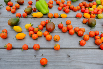 Fototapeta na wymiar Ripe tomatoes with green pepper are scattered on a wooden table for publication, design, poster, calendar, post, screensaver, wallpaper, postcard, banner, cover, website. High quality photo